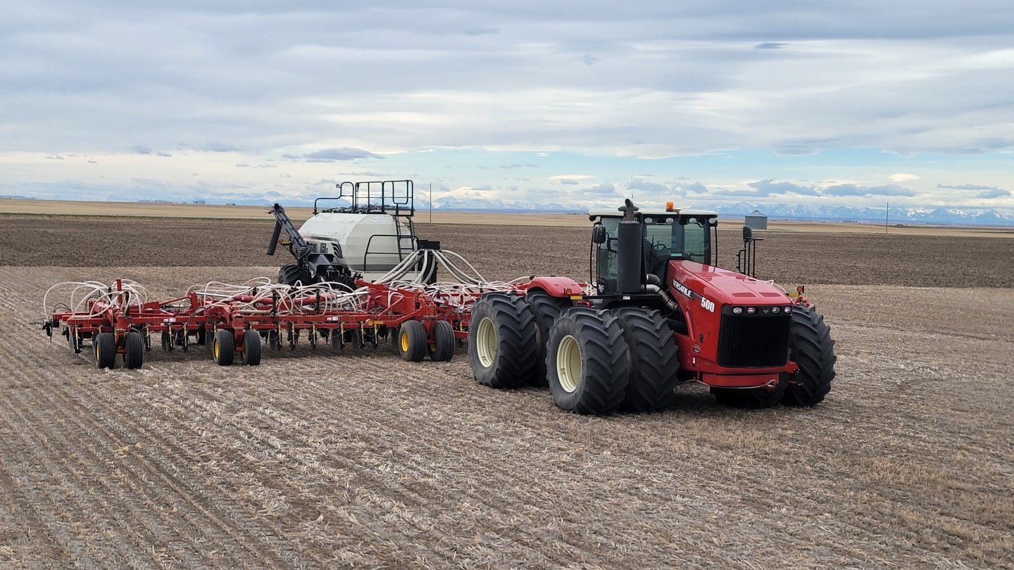 Versatile tractor pulling a Bourgault air seeder