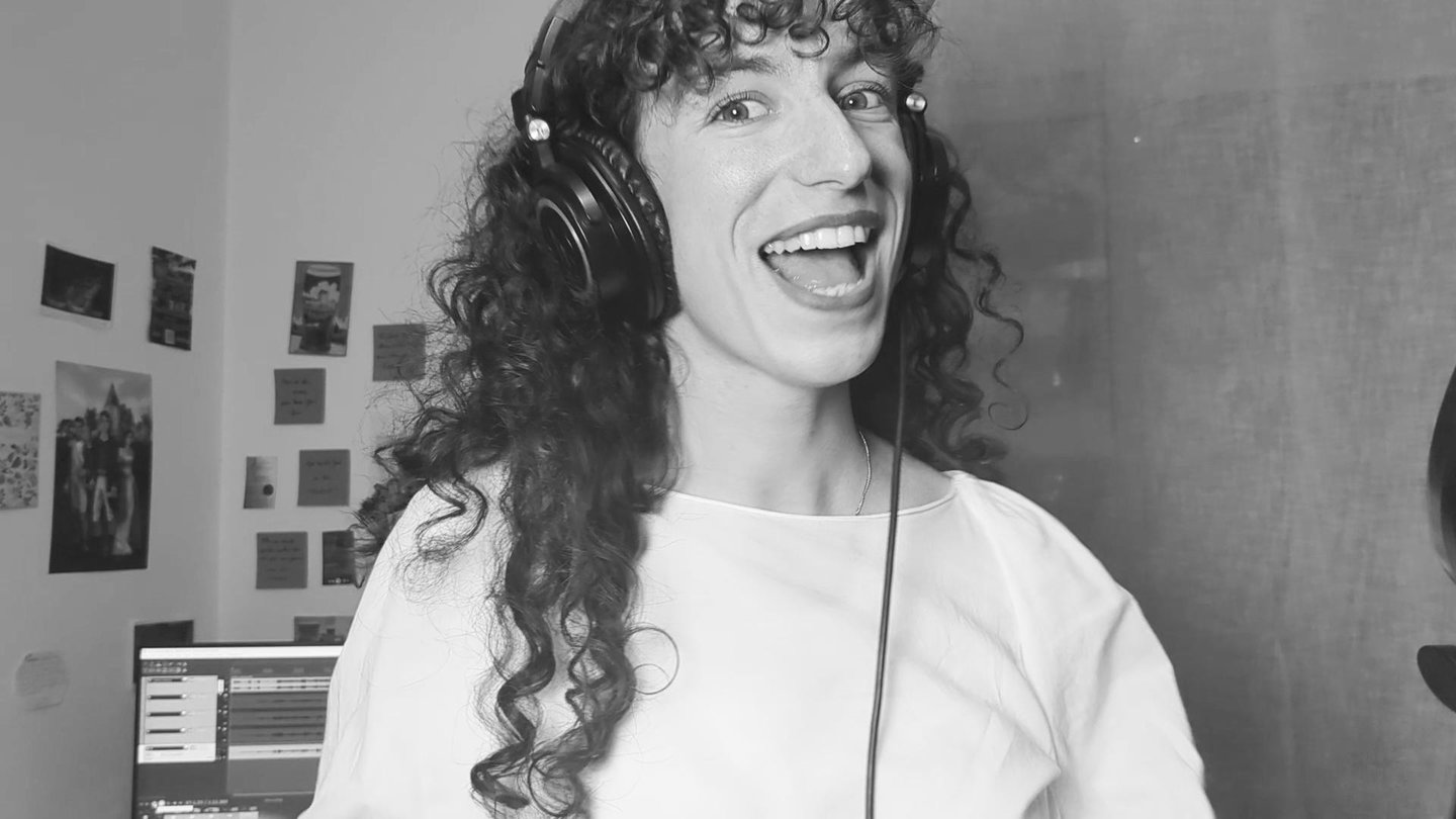 photo en noir et  blanc de aude fy en train de chanter avec casque sur les oreilles
