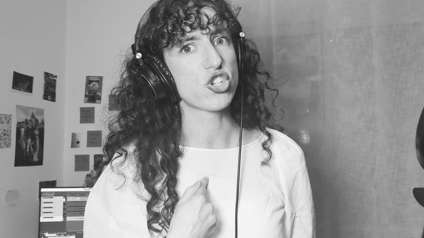 photo en noir et  blanc de aude fy en train de chanter avec casque sur les oreilles