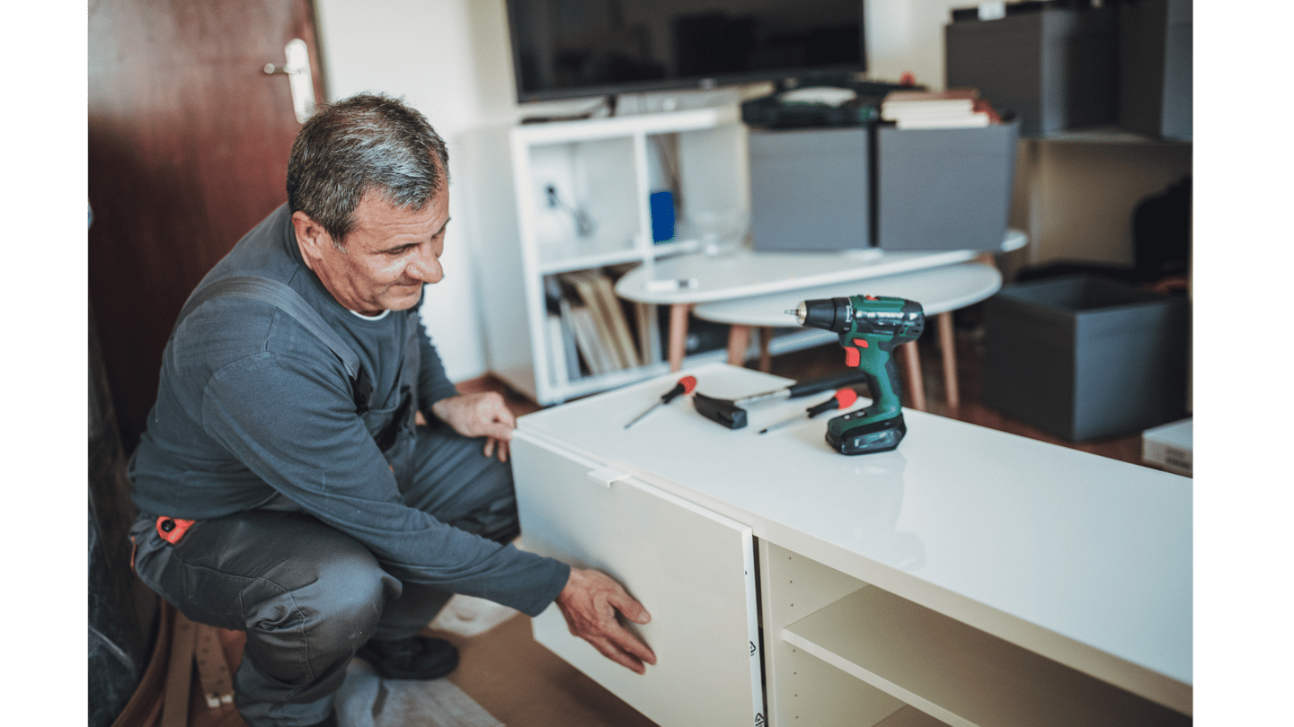 a man in a gray shirt is holding a drillet
