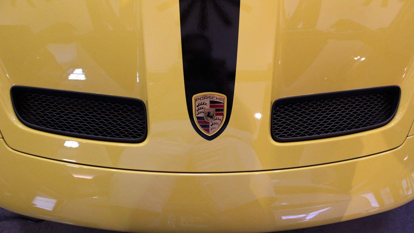 Porsche logo centered on the hood of a yellow Porsche 911 GT3