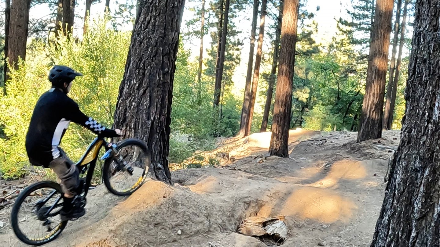 mountain biker going up the takeoff of a small jump