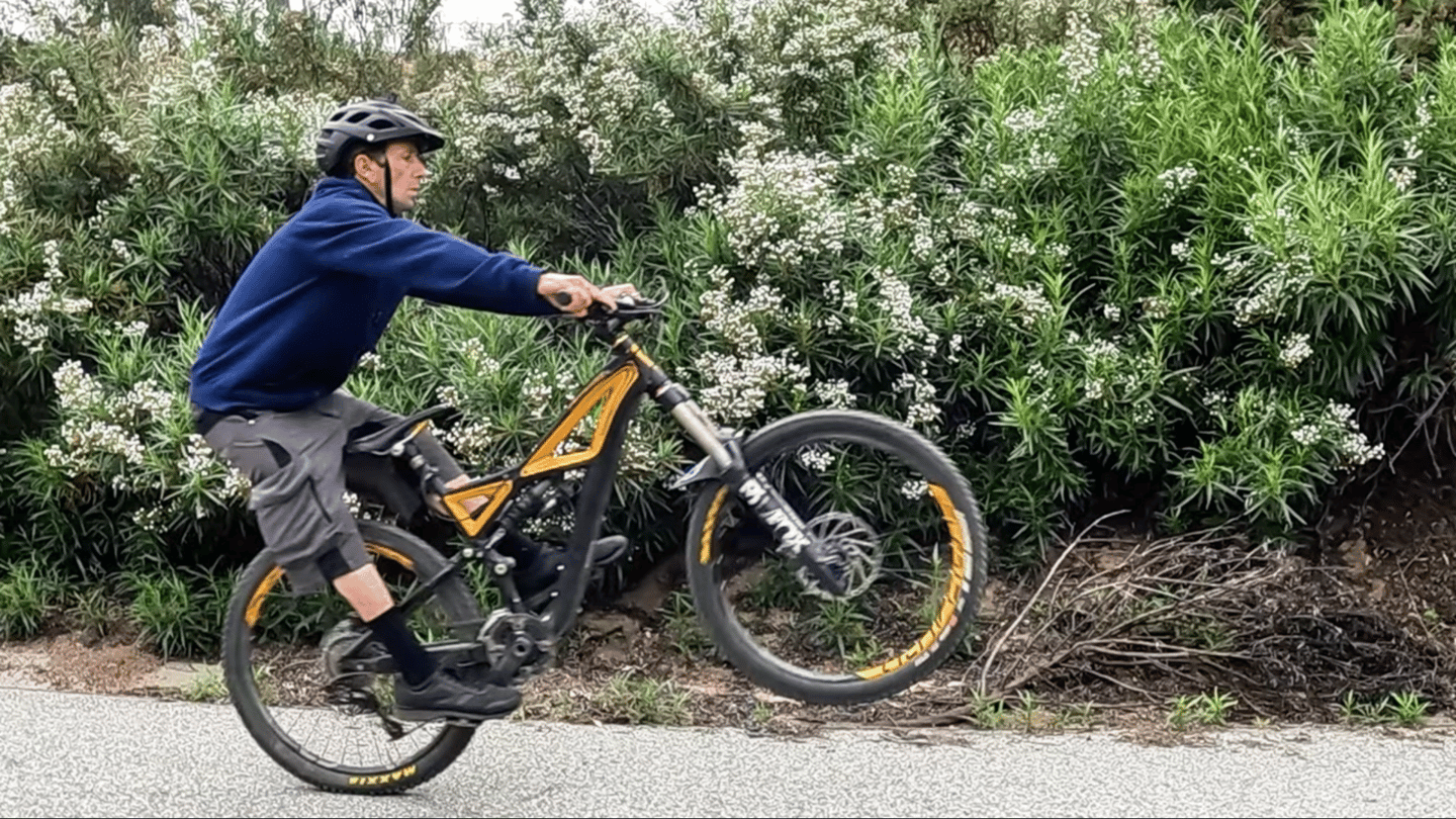 mountain biker lifting front wheel for a seated manual