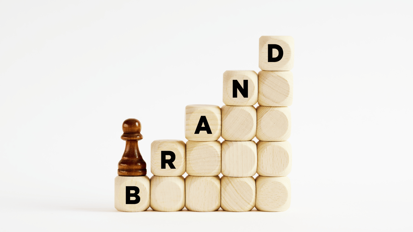 a chess game with a chess piece of wood blocks spelling the word "BRAND"