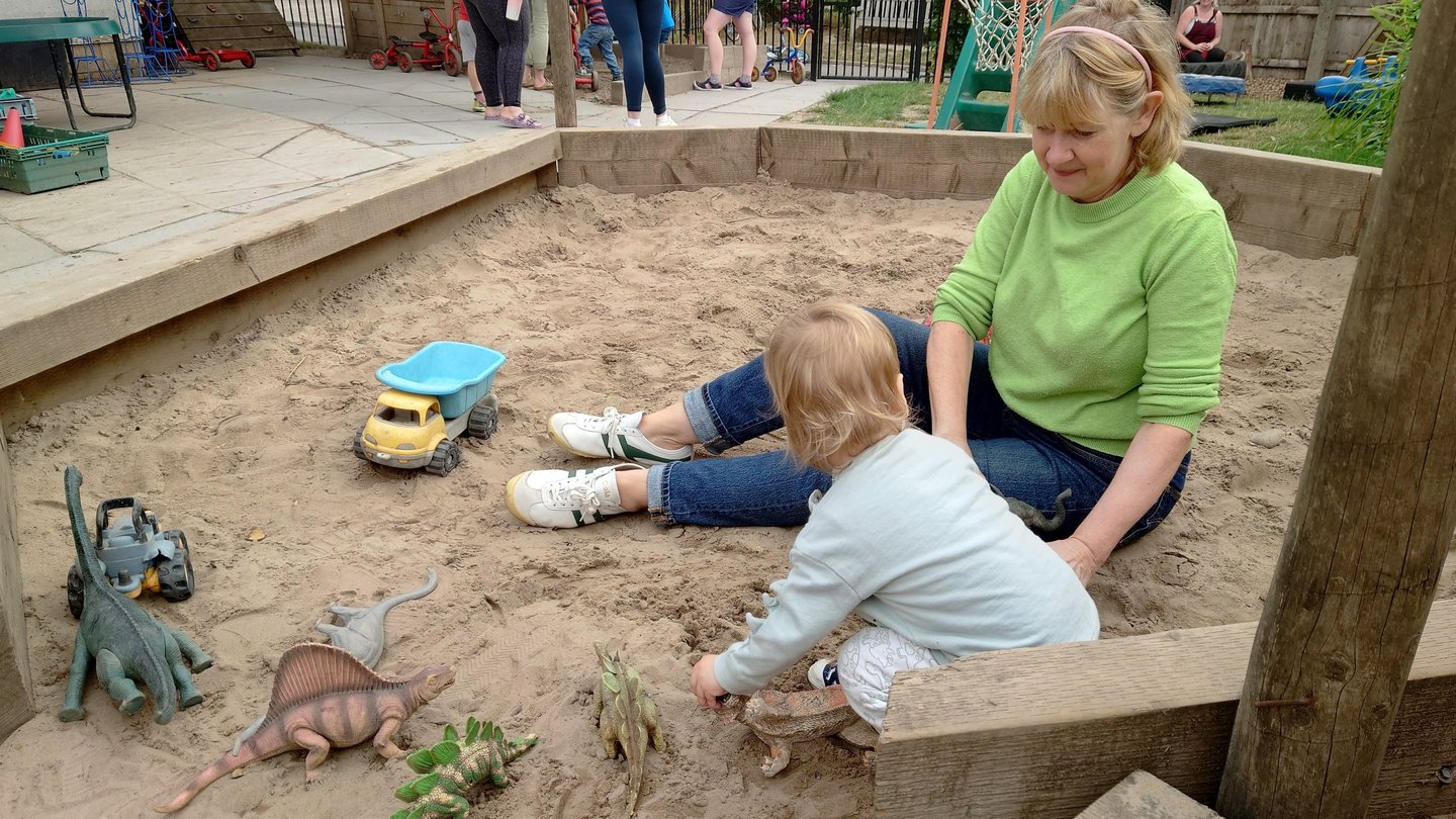 stay and play in the sand pit with volunteer members, children and their carers