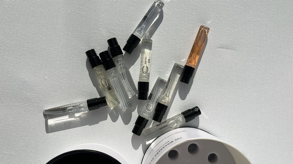 Una variedad de pequeños frascos de muestra de perfume esparcidos.