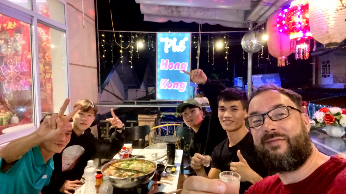 a group of people sitting at a table with food