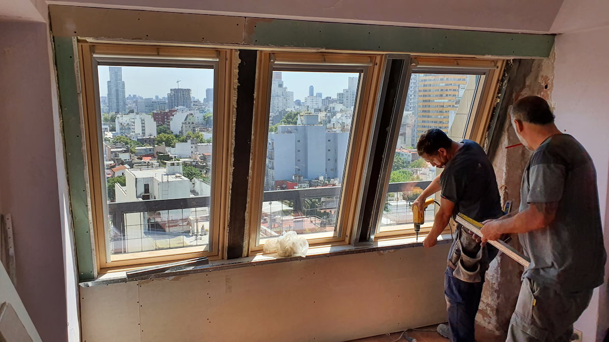 Professional contractors installing modern energy-efficient windows in a high-rise apartment renovation.