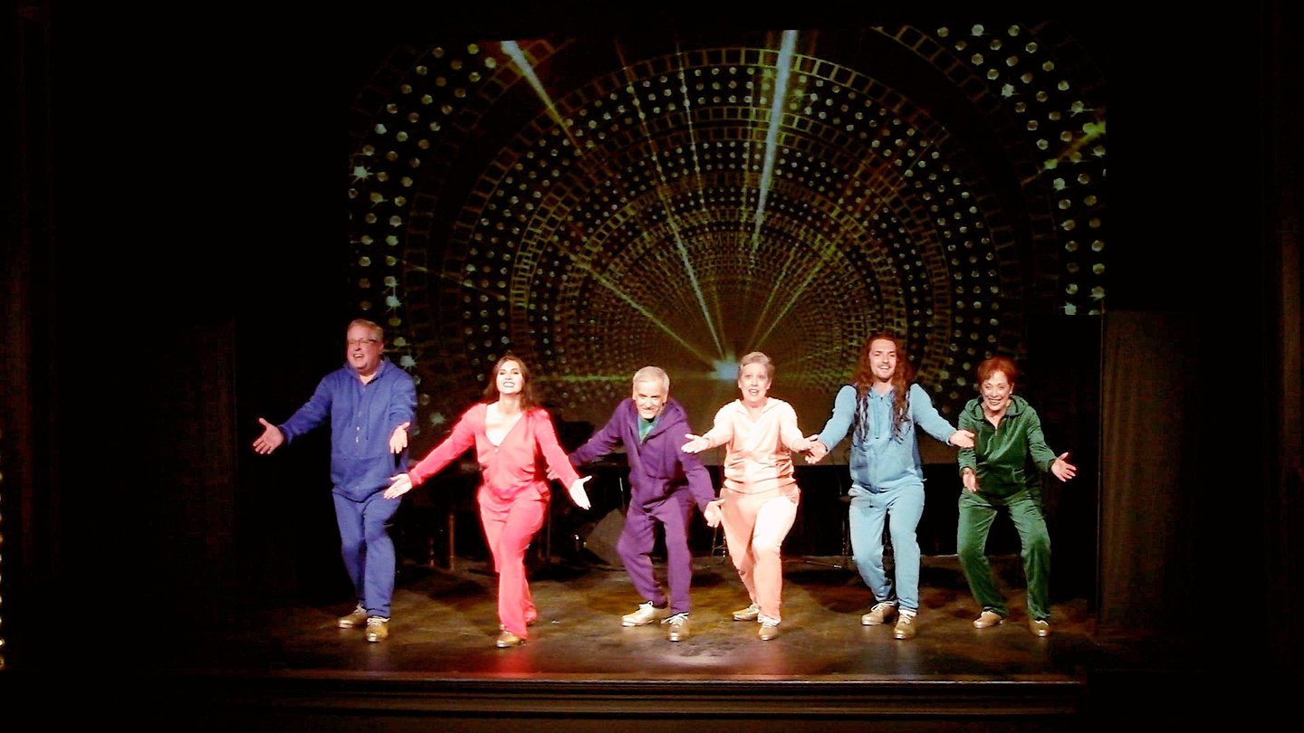 A diverse cast of tap dancers in colorful tracksuits performing the final of Alive and Kicking