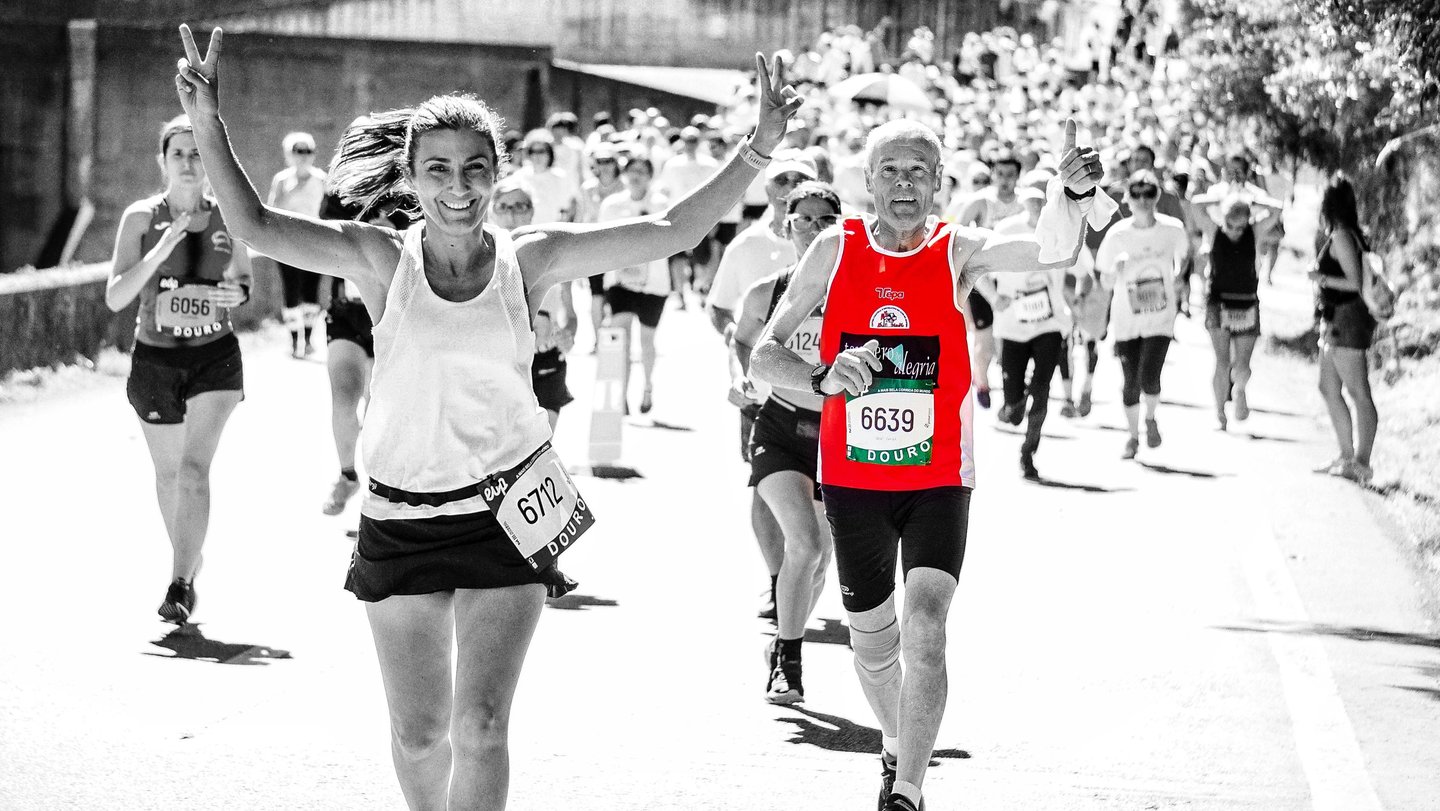a woman and an old man running in a marathon race