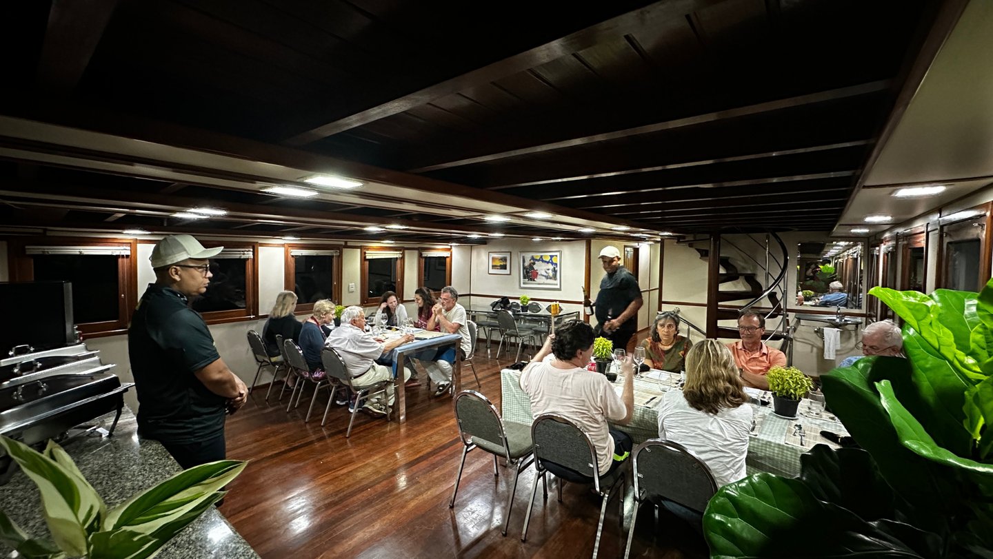 a group of people sitting at a table with food