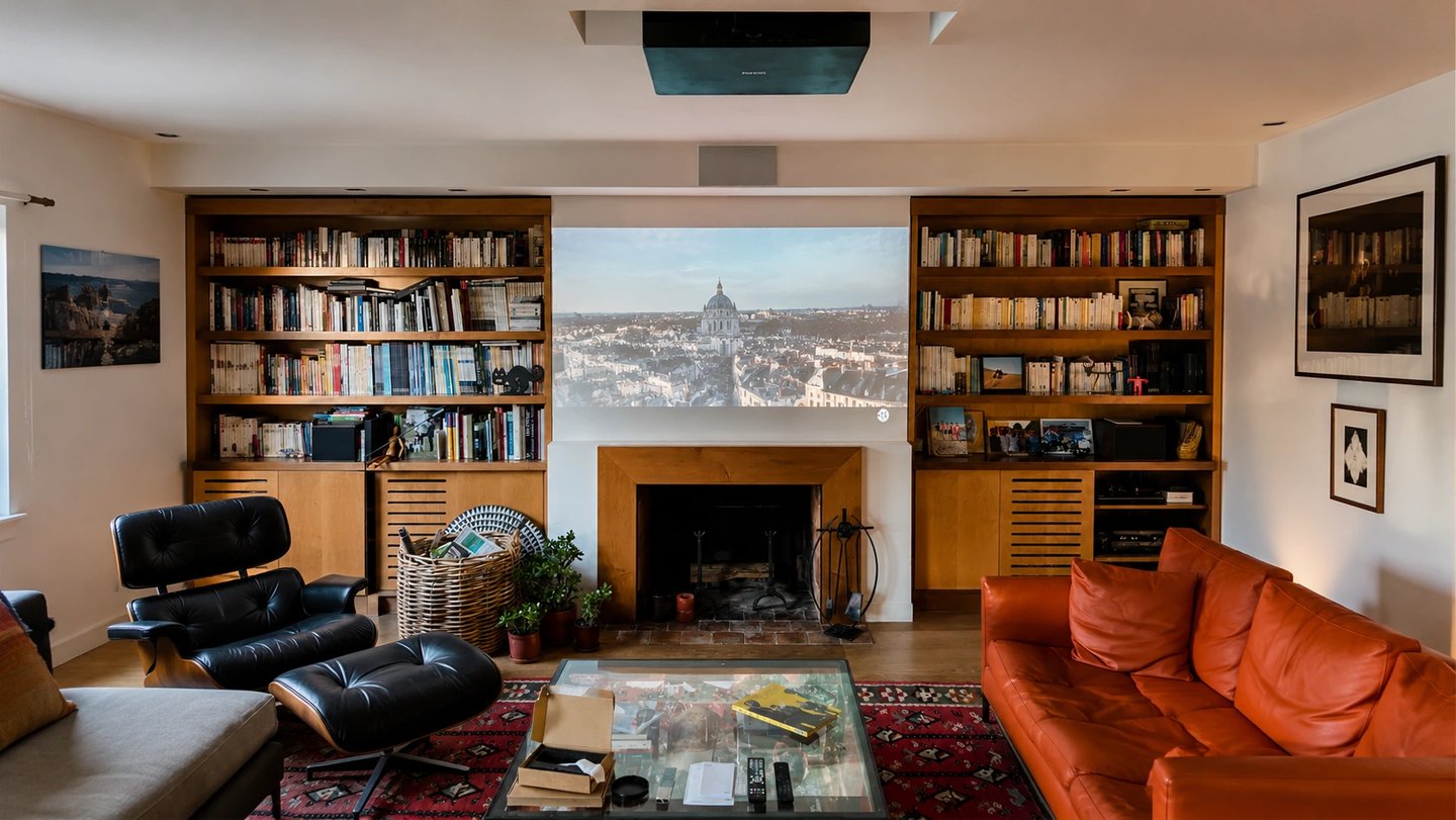 Salon privé transformé en espace cinéma avec vidéoprojecteur plafond et écran de projection