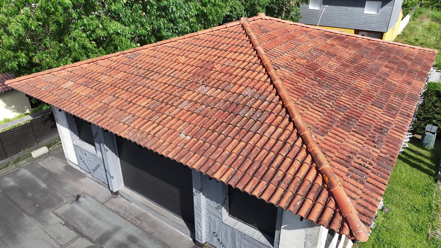 Vue aérienne d'un bâtiment résidentiel avec un toit en argile altérée avec des crêtes de hanche