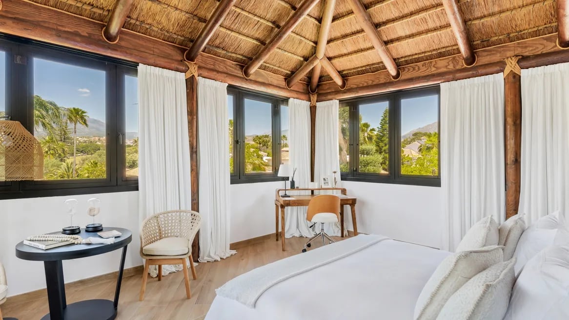 Penthouse suite with thatched ceiling and panoramic mountain views at Villa El Olivo, Marbella