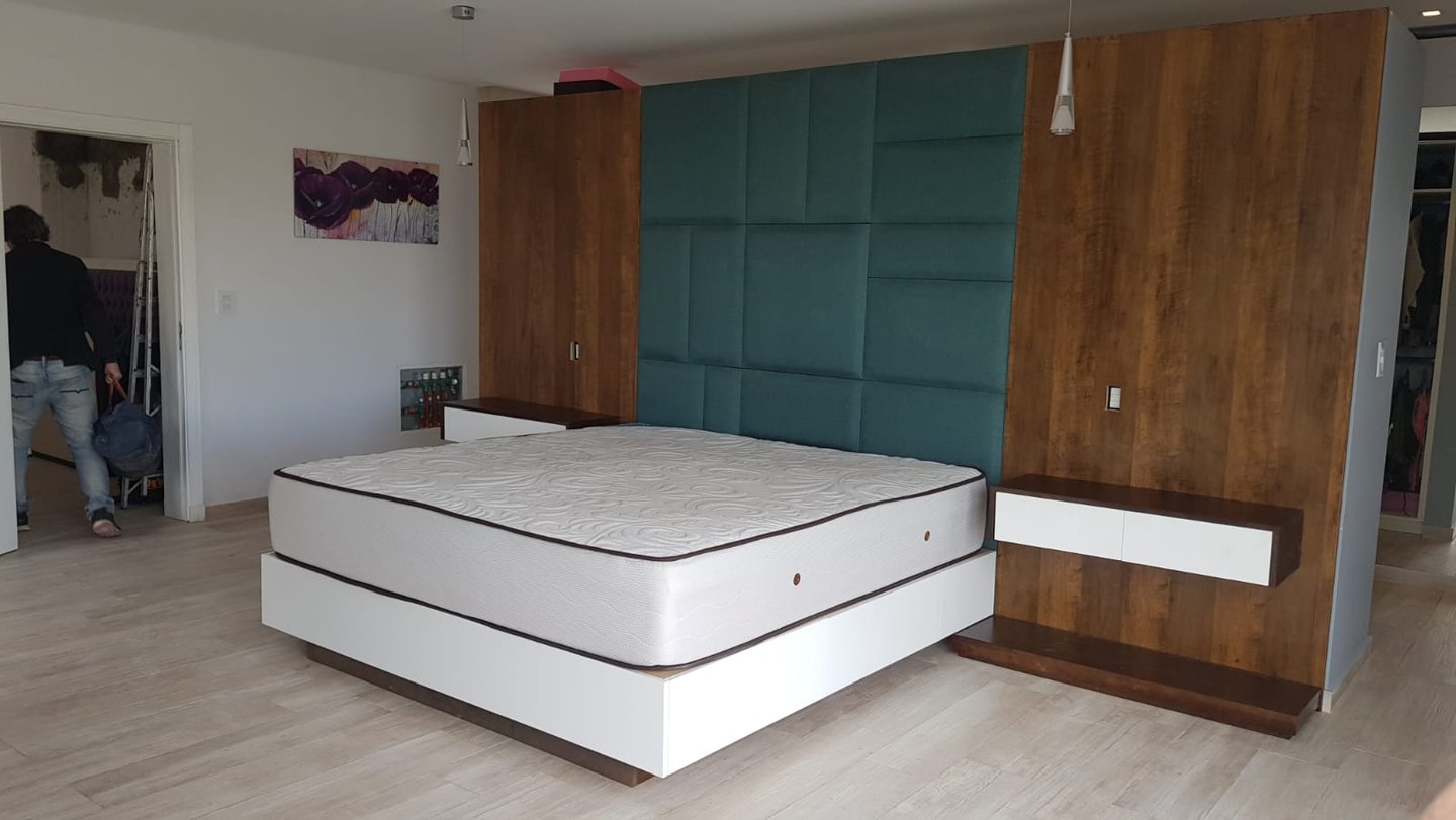 Diseño de dormitorio integrado con respaldo de cama, mesas de luz colgantes y box de cama