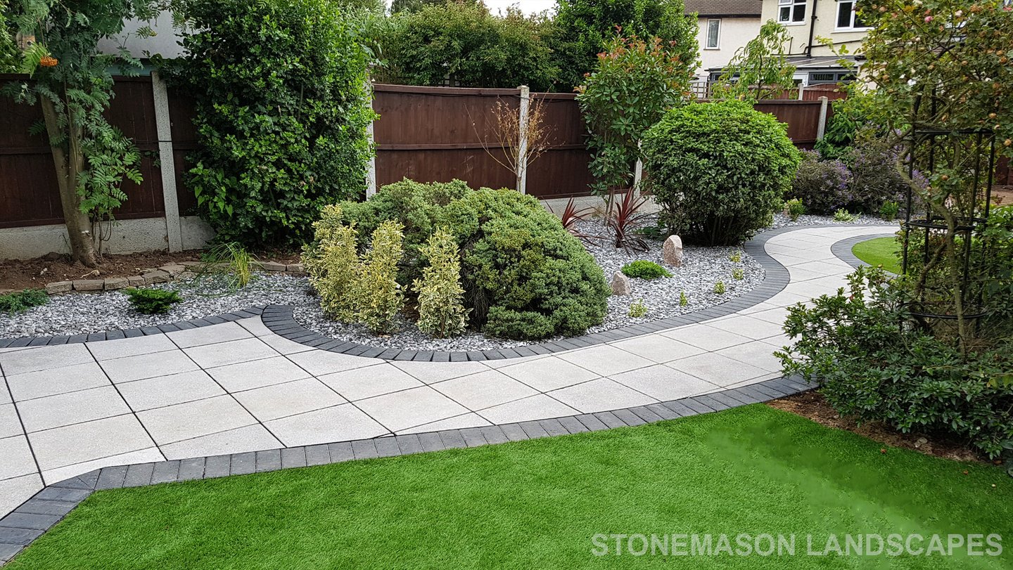 Patio with custom stone circle with aggregates and paving weaving through adventurous garden design