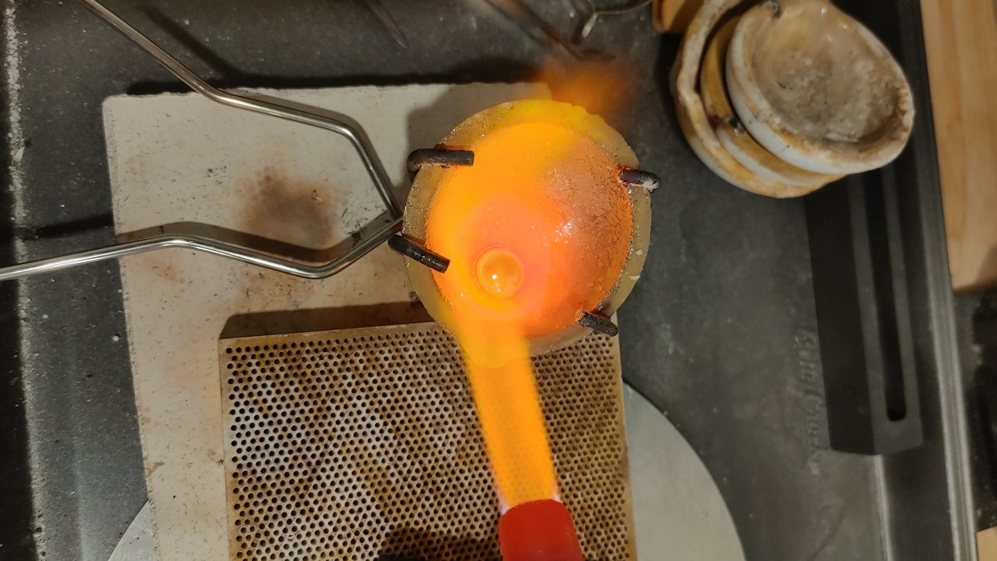 Molten sterling silver being heated and poured during the jewelry-making process.