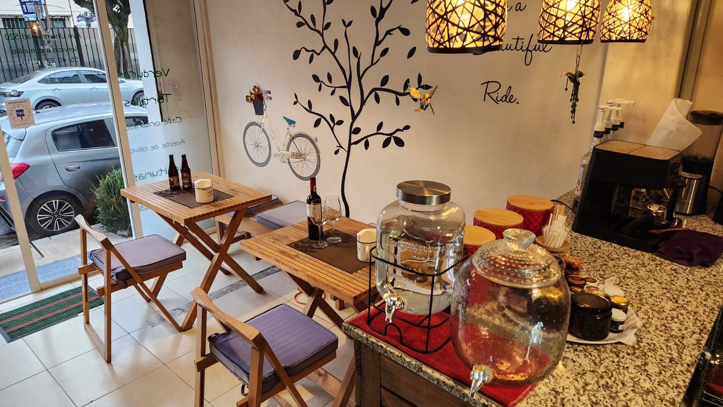 a cafeteria with a table with a wine bottle and a glass of wine