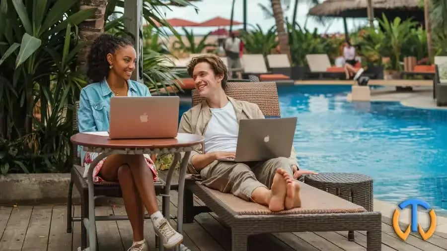 Un couple de nomades digitaux devant une piscine