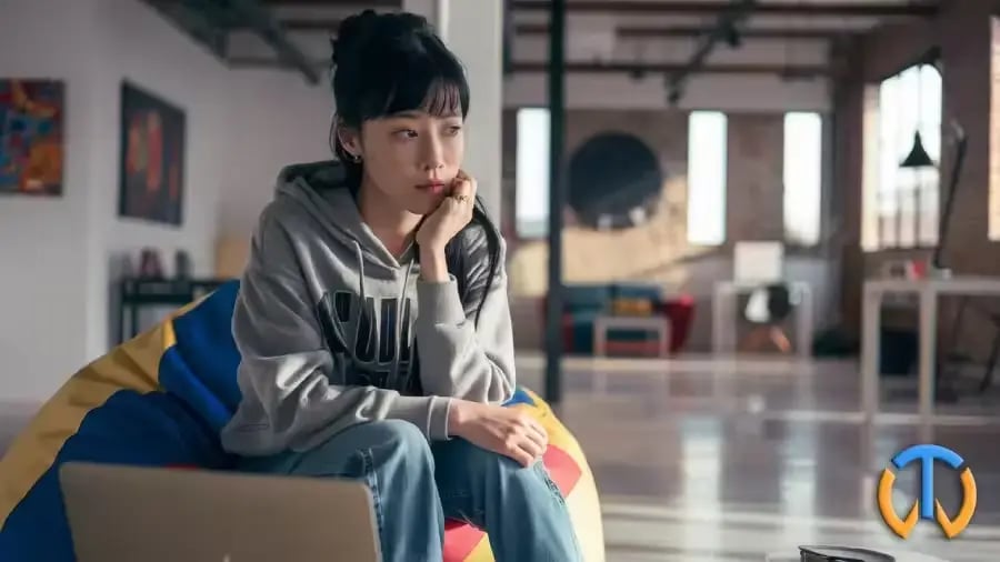 Une jeune asiatique songeuse dans un co working