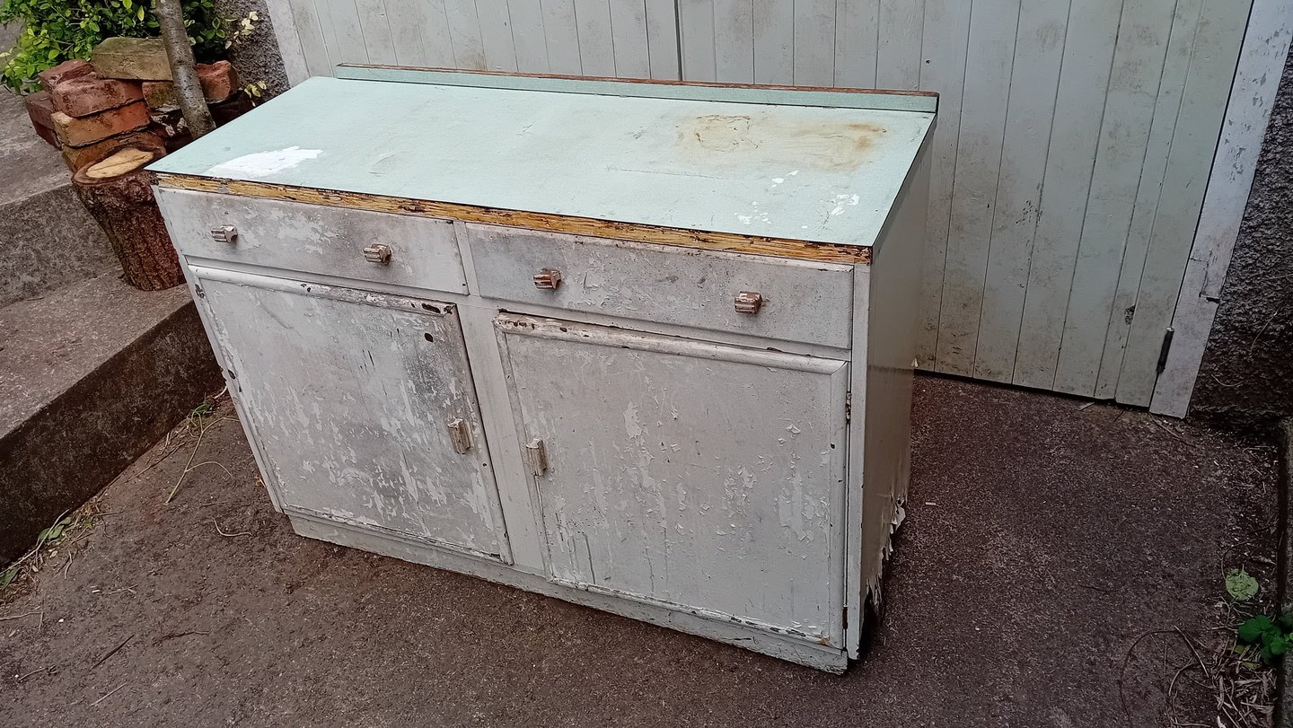 Dilapidated cupboard with peeling white paint