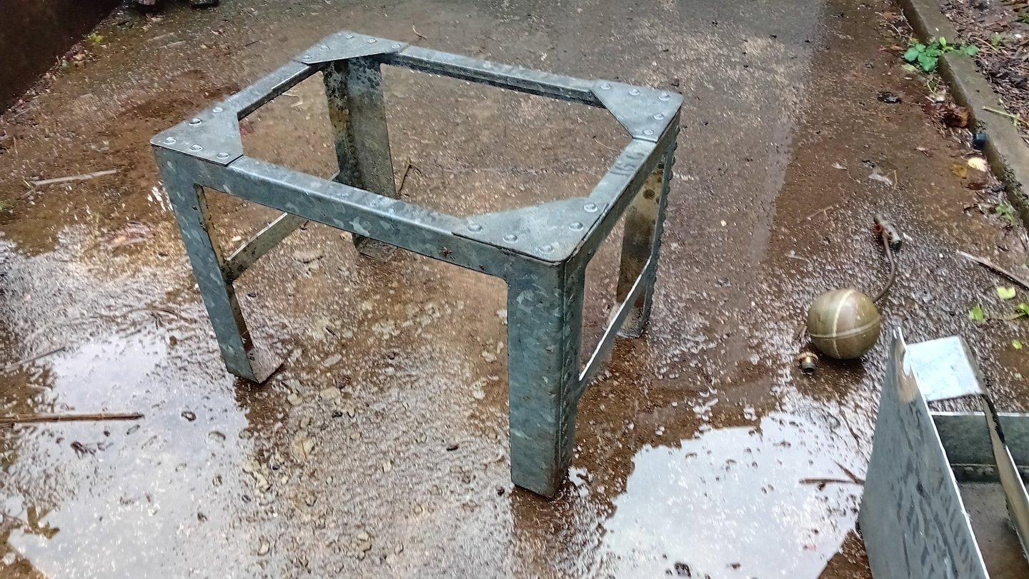 The sides and base of the tank have been cut away to leave 4 legs with cross bars and the top edges