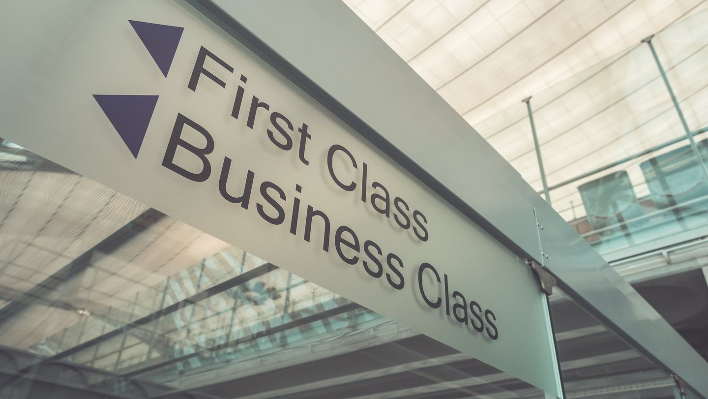a sign that says first class business class in airport