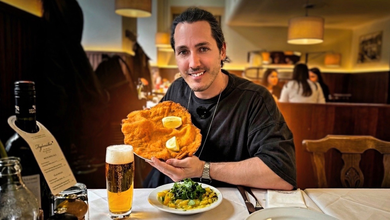 Primer plano de un Schnitzel de Viena gigante servido con rodajas de limón, guarnición de ensalada