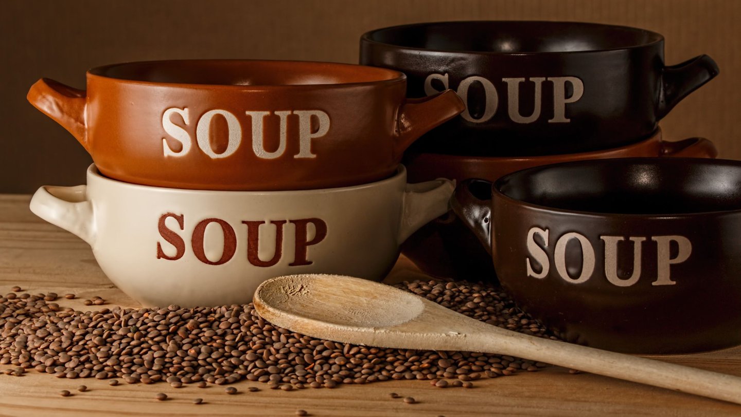 a variety of soup bowls with spoons and spoons