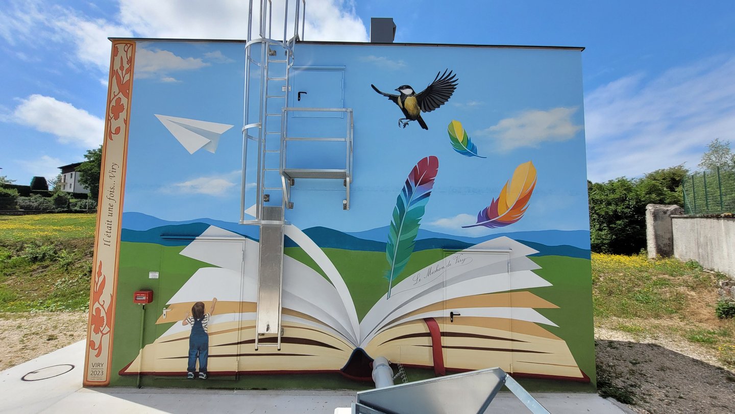 Fresque sur façade ext., plume écrivant sur un livre ouvert, un enfant et oiseau sur paysage épuré.