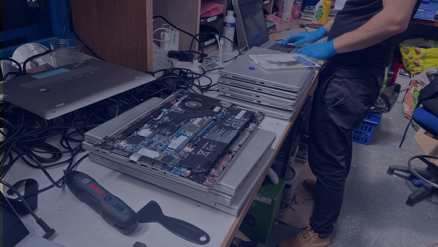 Photo of one of the technical team at work on a batch of laptops