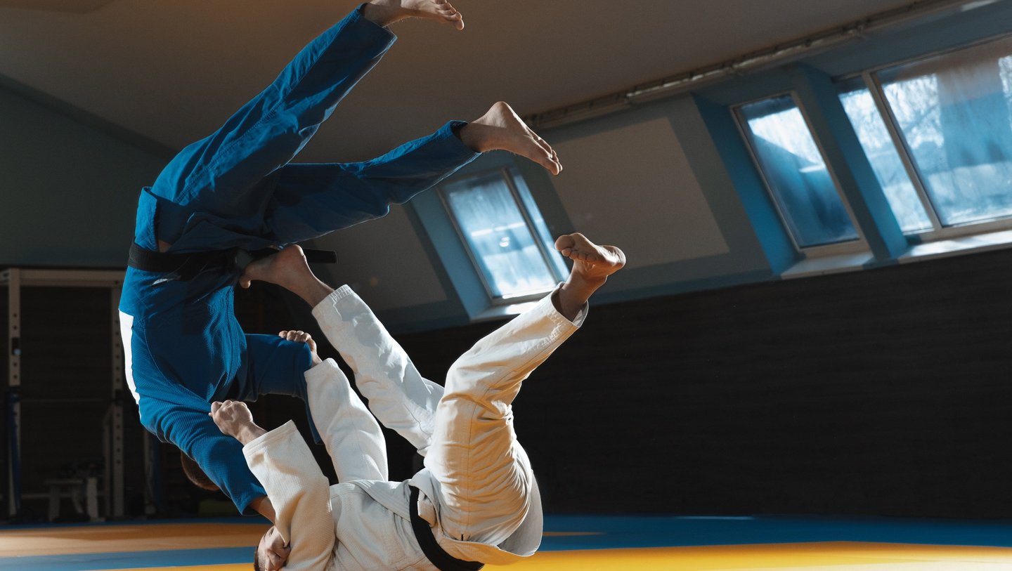 Judokas ceinture noir, réalisant une projection de judo sur un tatami