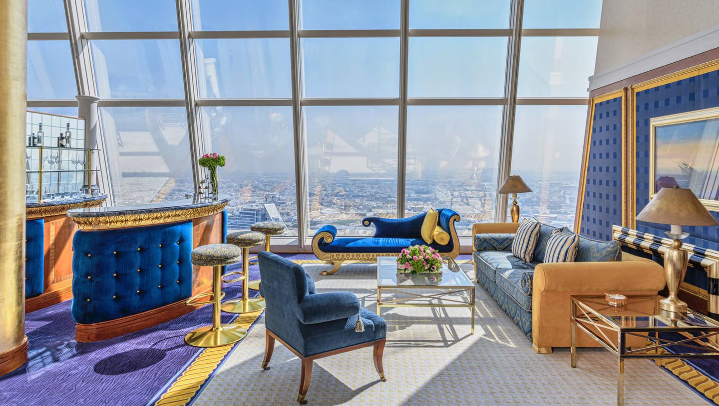 Burj Al Arab luxury hotel suite with panoramic city views and opulent blue and gold decor.