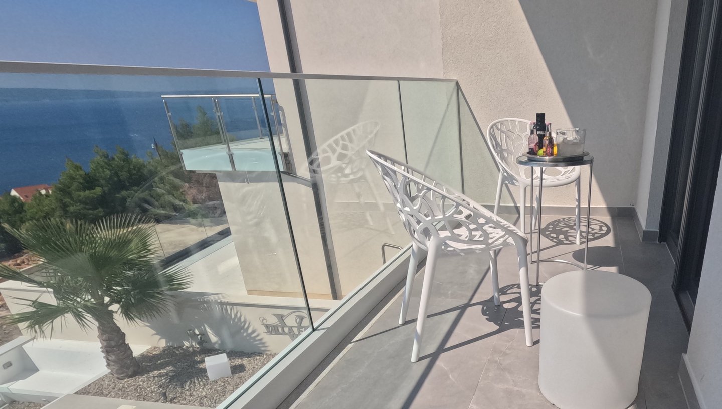 Villa Fay balcony with a table and chairs and a bottle of wine