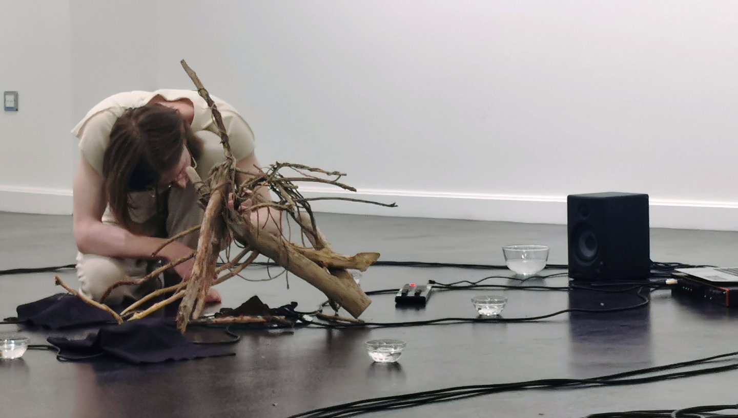 performance artist with wooden sculpture