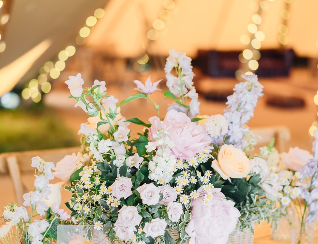 a table with a basket of pastel wild flowers