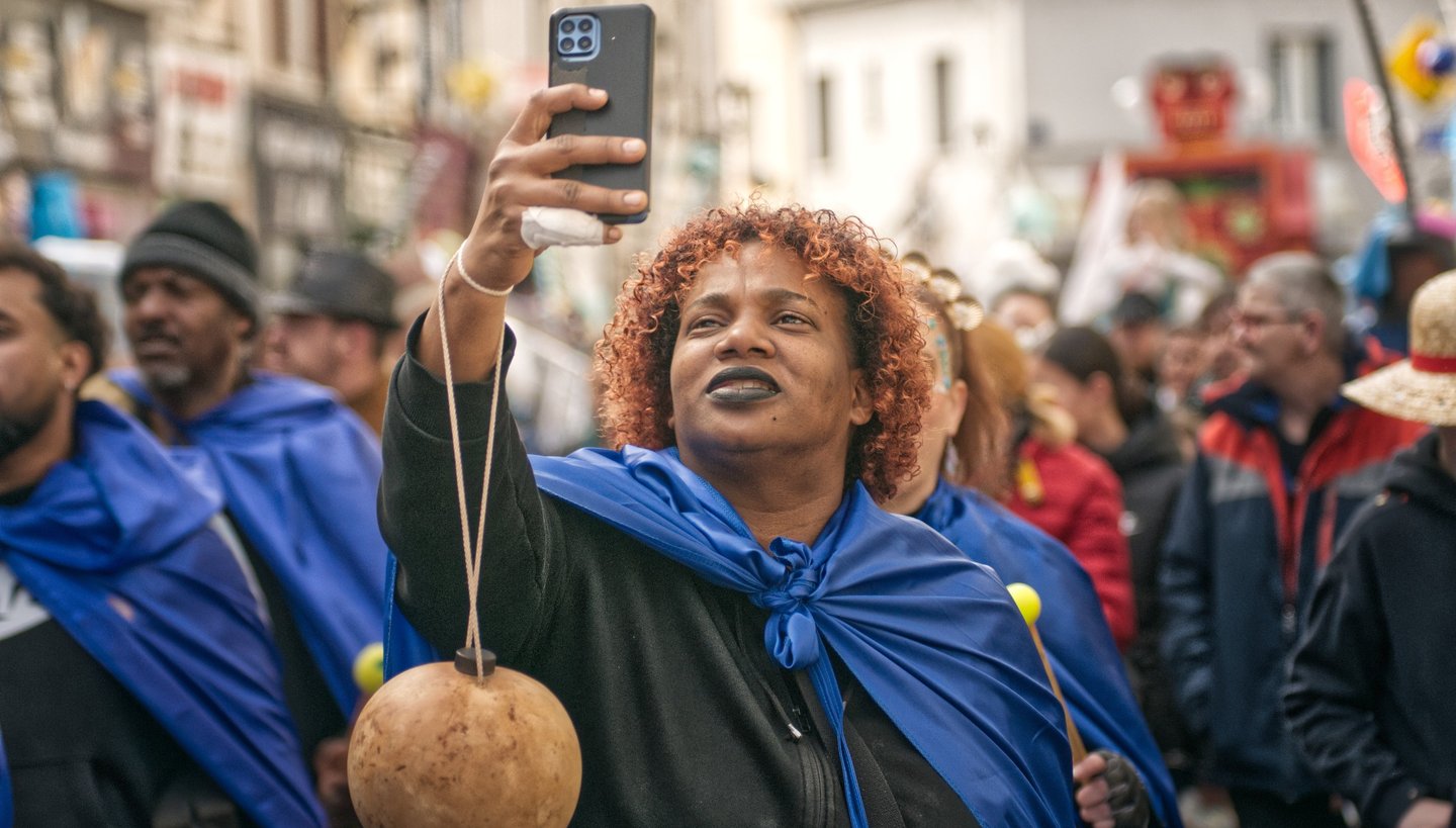 Femme photographiant la foule lors d’un événement à Illiers-Combray — reportage photojournalistique 