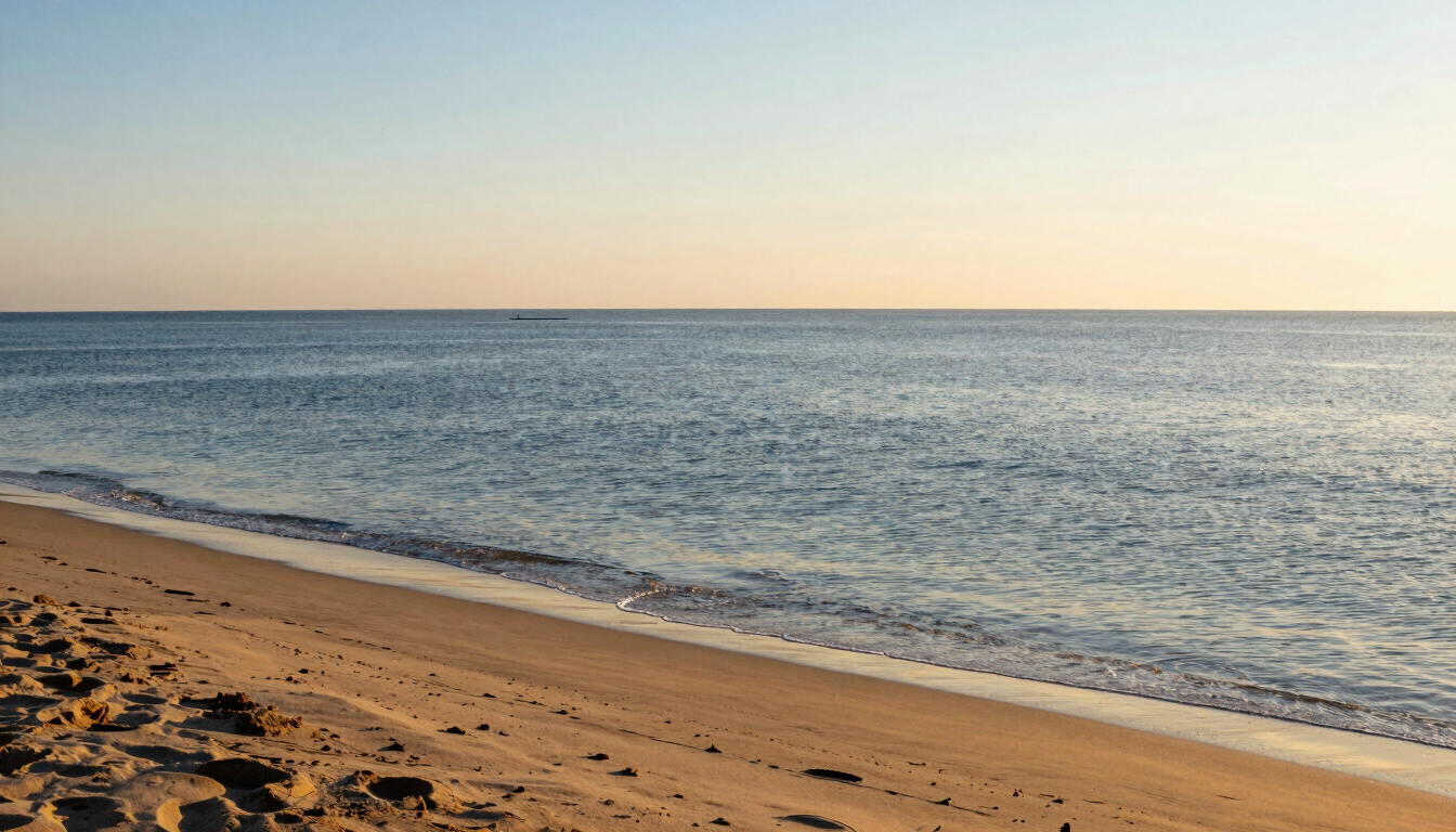 Wide golden-hour vista of the San Felipe coast, calm blue water meeting sandy shores, soft warm light, 35mm lens.