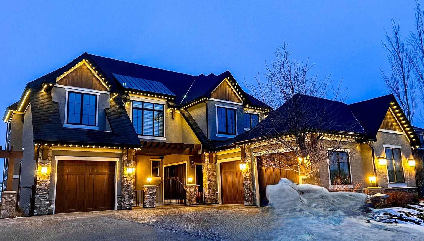 House exterior illuminated with energy -efficient permanent holiday lighting.