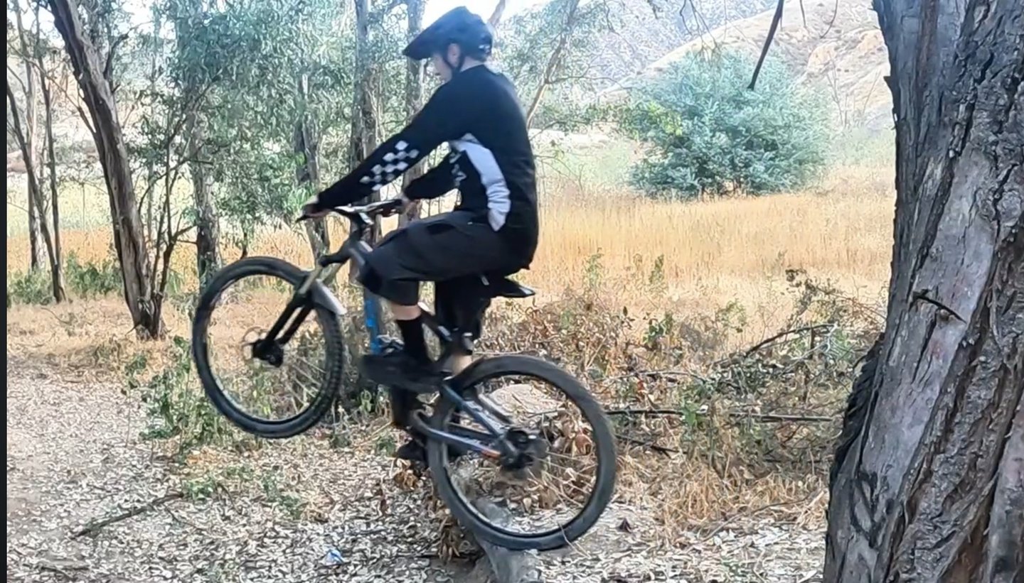 mountain biker riding off a small drop off