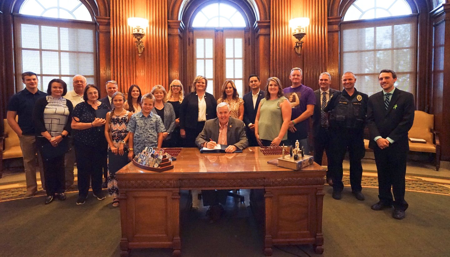 Large group of people in the governor's office, posing for a picture