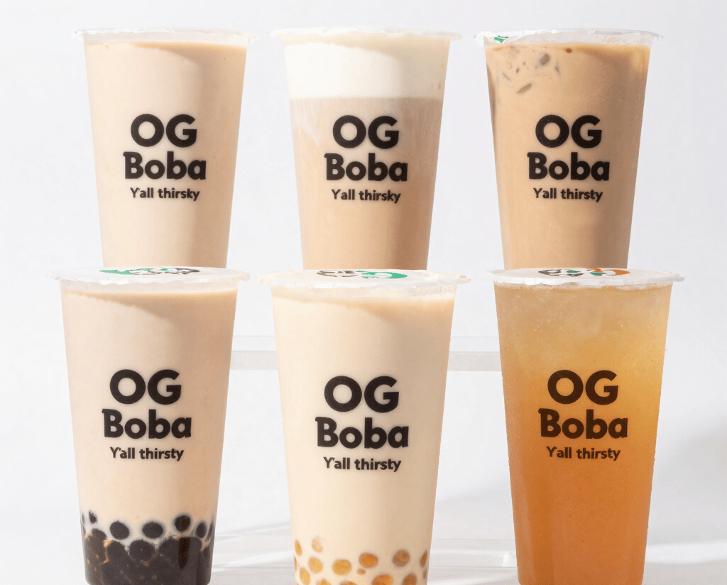 A vibrant cup of OG Boba with colorful tapioca pearls and fresh tea, set against a warm, inviting background.