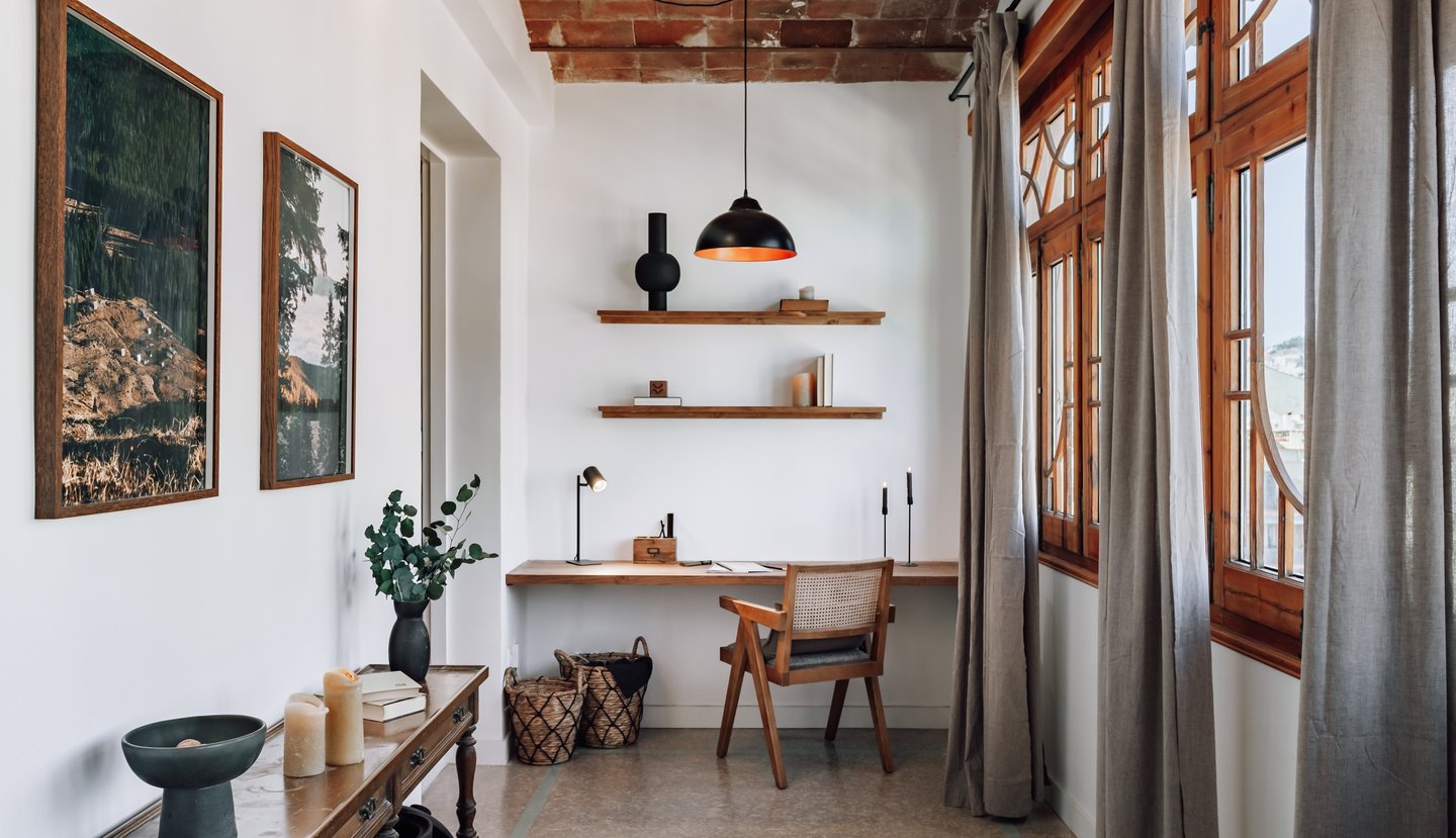 Rustic elegant working area design with wooden elements and art and big windows in Barcelona