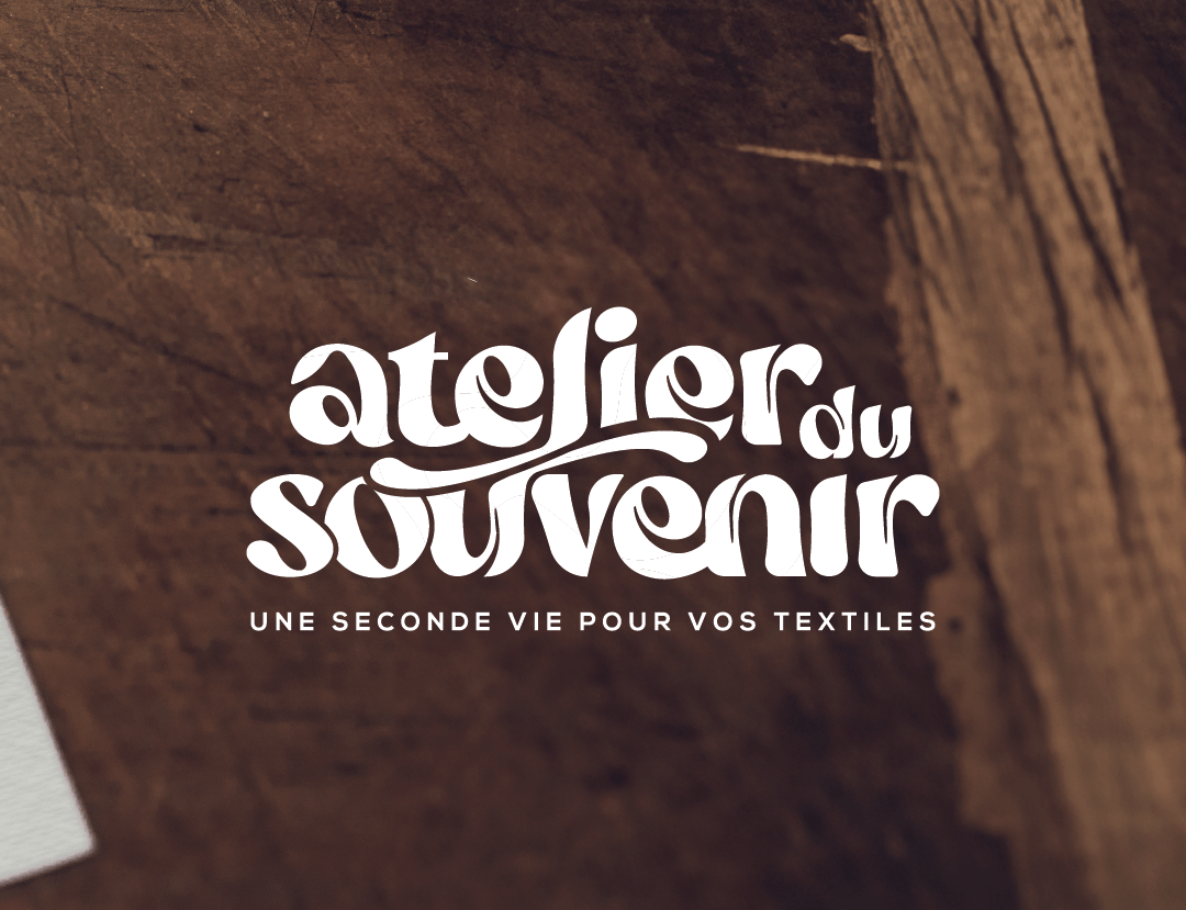 Logo L'Atelier du Souvenir sur fond bois brun, design par Marion Guizzardi, directrice artistique, Montpellier.