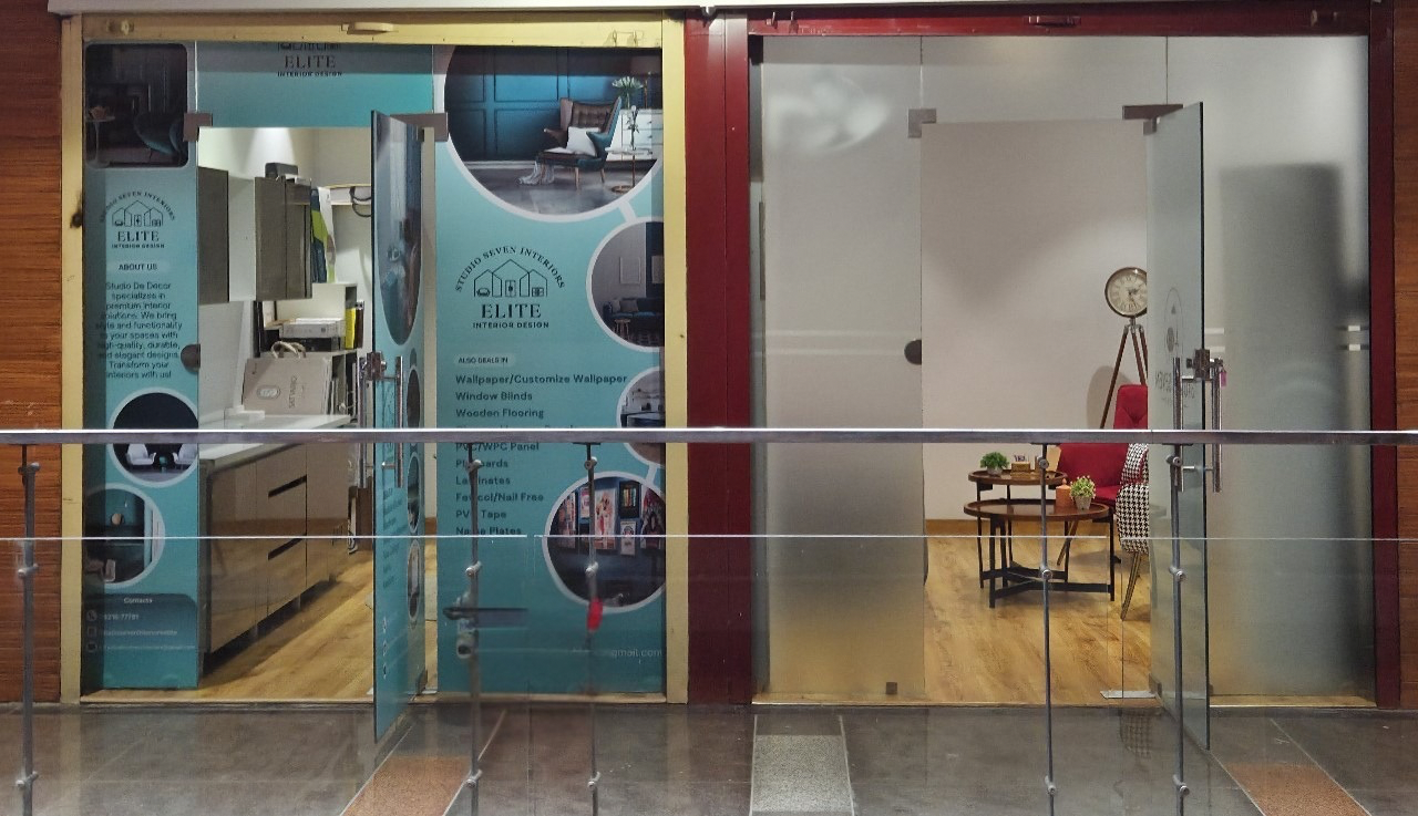 Elite Interior Design studio storefront with glass doors and decorative wallpaper samples.