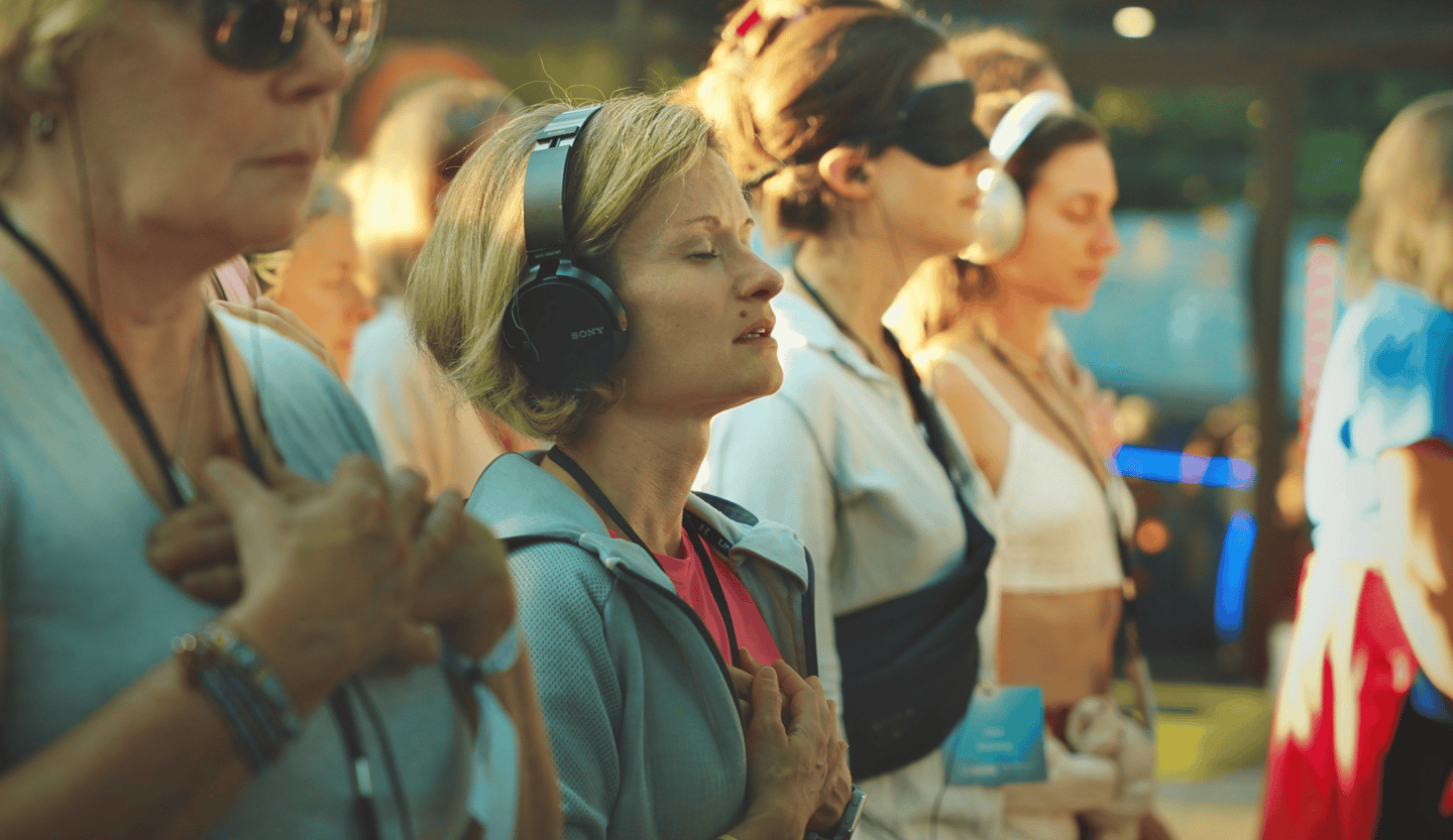 Laura the founder with a group of female participants, using headphones, during a meditation session