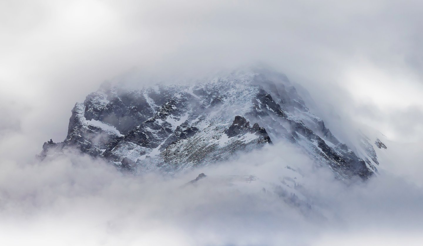 A minimalist photo of a mountain during a snow storm.