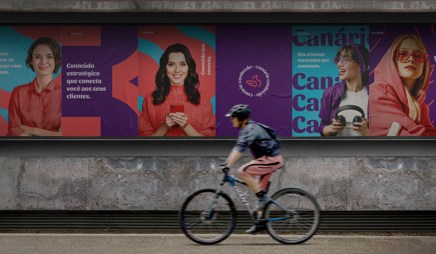 a person riding a bicycle in front of a large advertisement