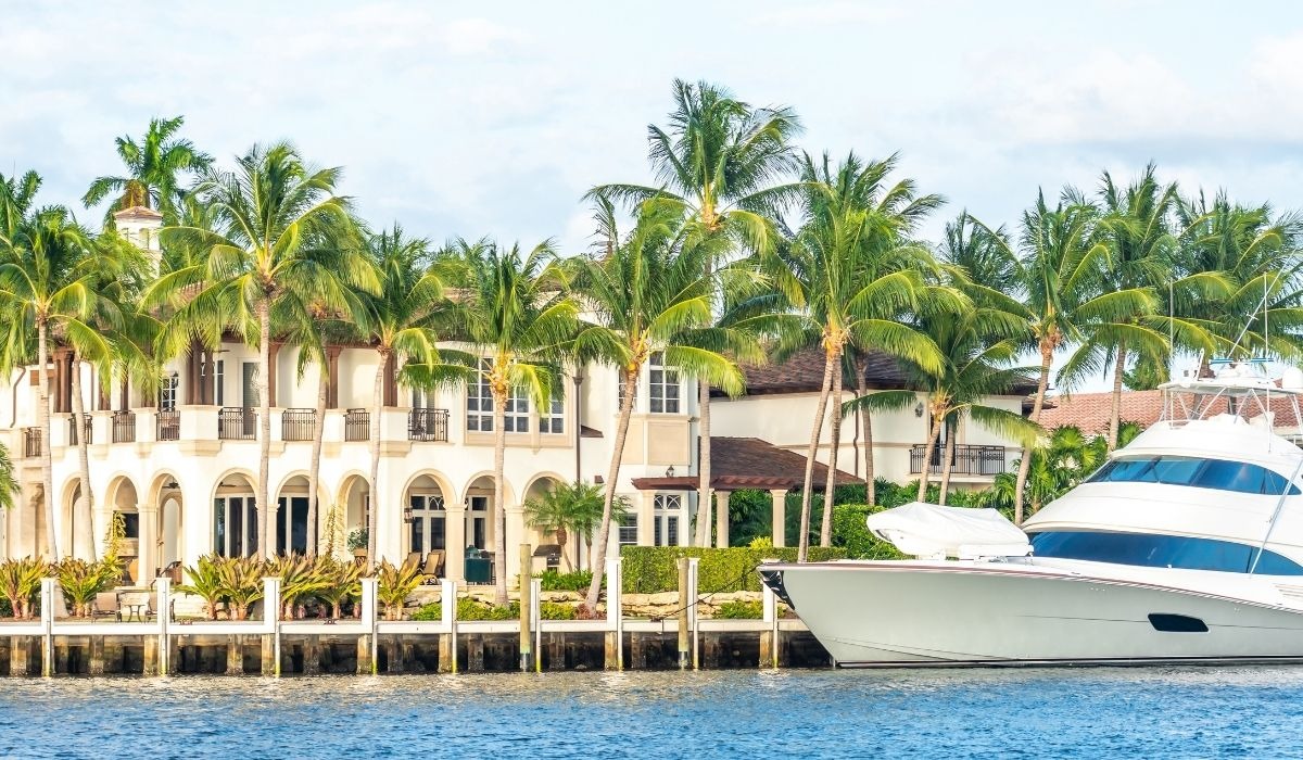large yacht next to large home in florida