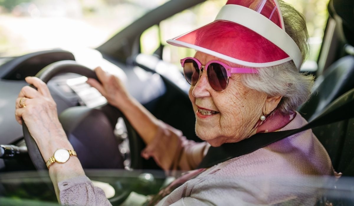 old lady with sun visor driving car